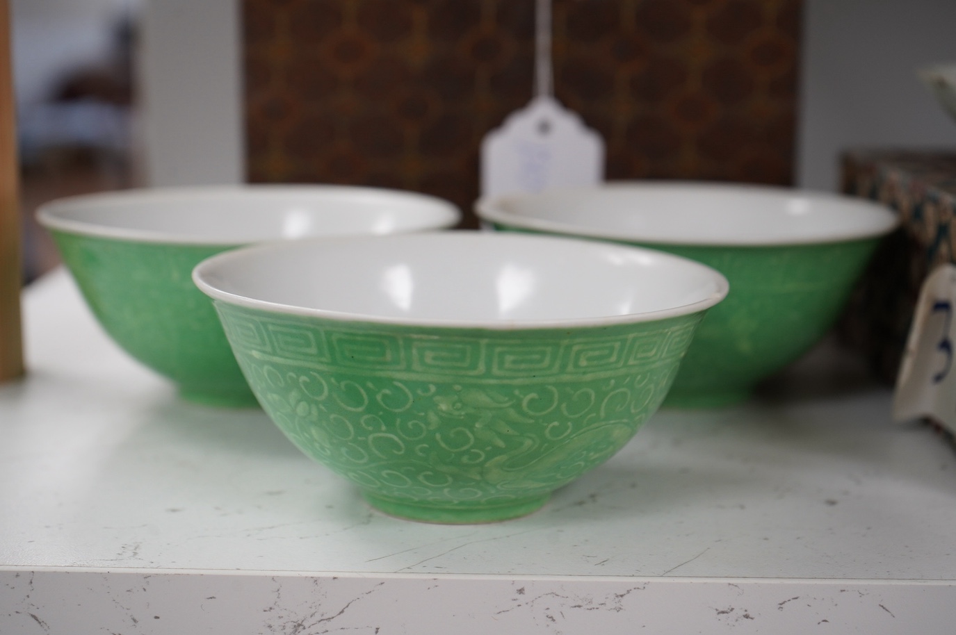 A set of four Chinese green glazed and moulded bowls and a famille rose dish, 19th and 20th century, boxed, largest 17cm. Condition - one bowl cracked